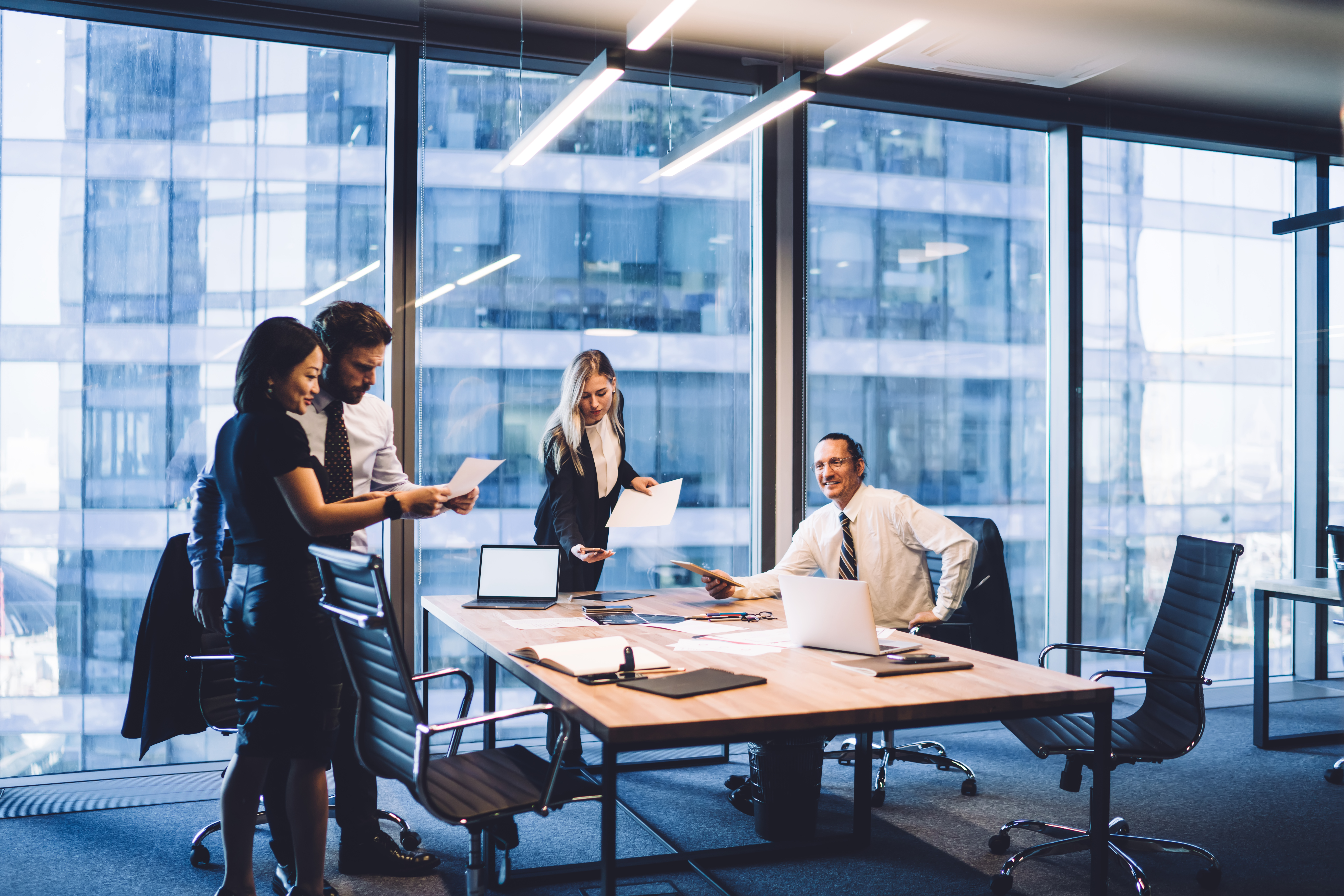 Group of diverse executive managers doing paperwork at meeting