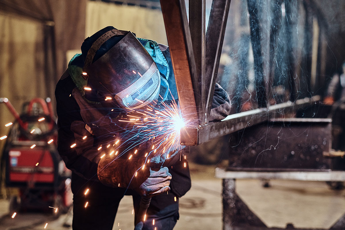 Man is working at the busy metal factory